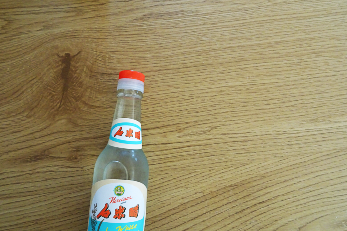 Aufnahme einer auf Holztisch liegenden Flasche mit chinesischem Text auf dem Etikett.